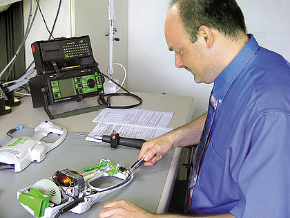 Testingenieur Christian Schlößner misst die Kriechstrecken in Elektrogeräten mithilfe eines digitalen Messschiebers.